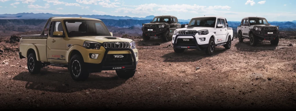 Mahindra vehicles standing on dirt road